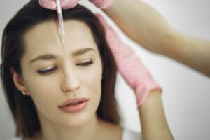 Concept image of glabellar Botox injection, showing syringe near forehead